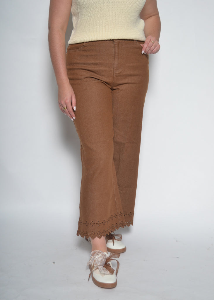 Person wearing brown pants with a white background