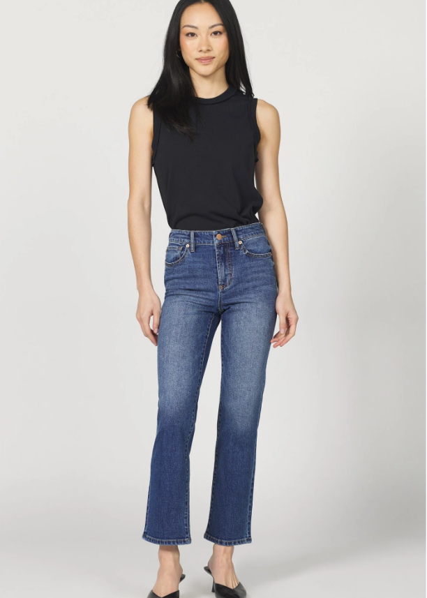 Woman wearing a black sleeveless top and blue jeans on a white background