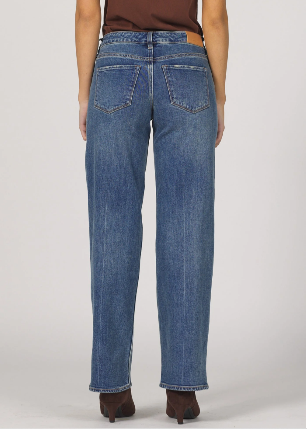 Person wearing blue jeans on a plain background