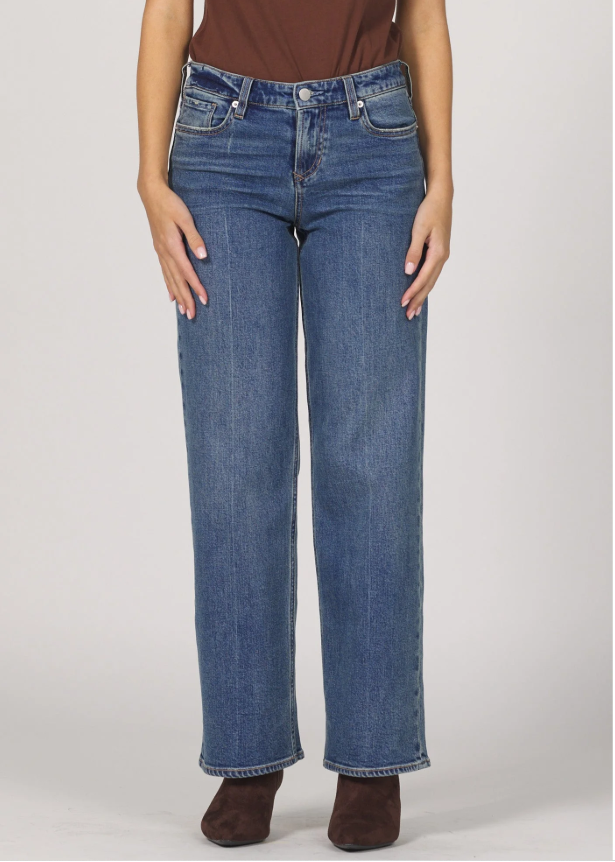 Person wearing blue jeans and a brown top on a plain background