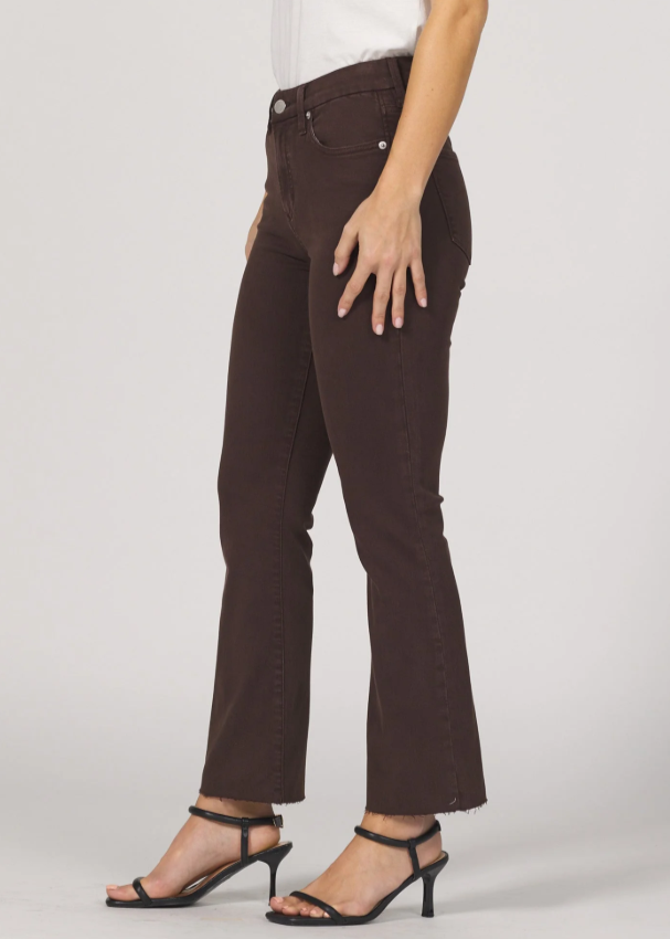 Brown jeans worn by a person on a plain background