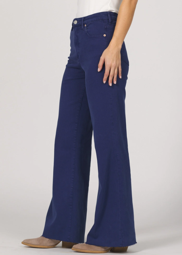 Navy blue jeans worn by a person on a white background