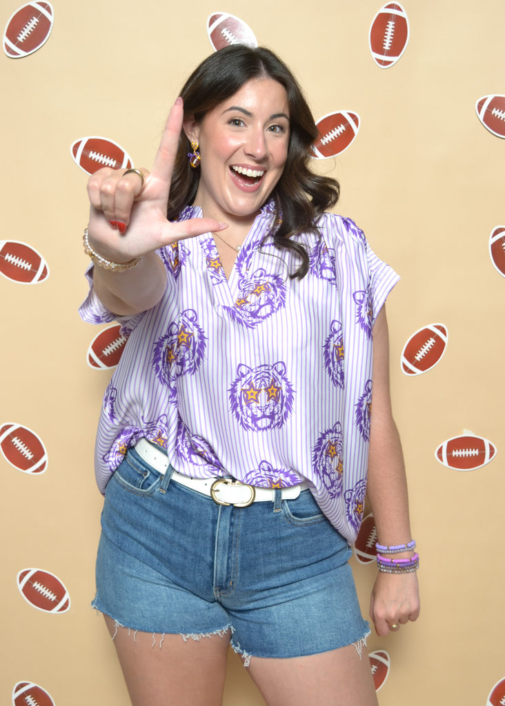 Woman making a peace sign with footballs on a beige background