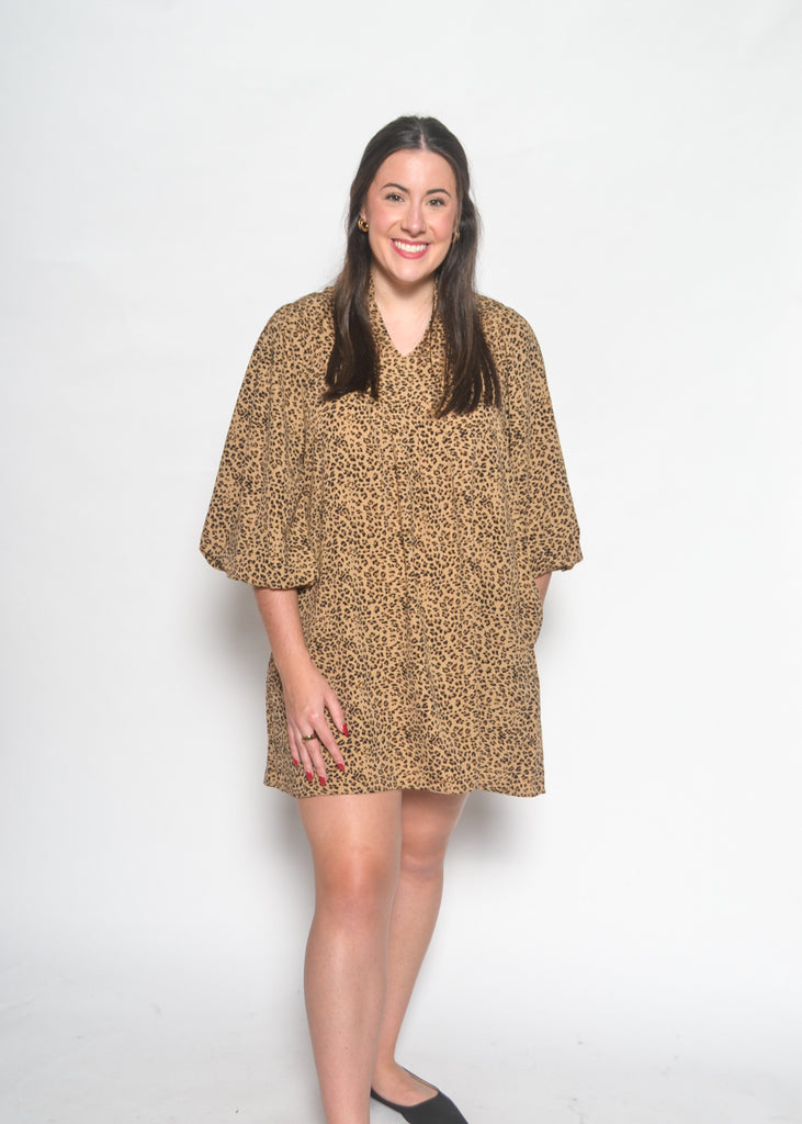 Woman wearing a leopard print dress against a white background