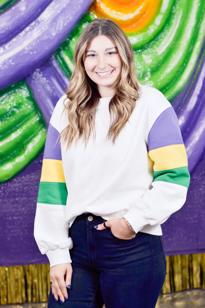 Person wearing a colorful striped sweater with a vibrant, abstract background